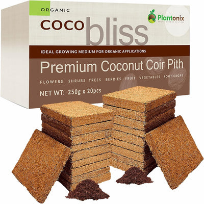Two stacks of coco coir bricks. The bricks are in front of a box of premium coconut coir pith. In front of the blocks are two loose piles of hydrated coco to show texture. 